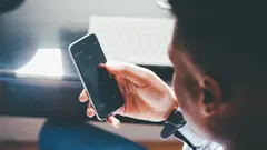 Un chico consulta su smartphone desde su casa