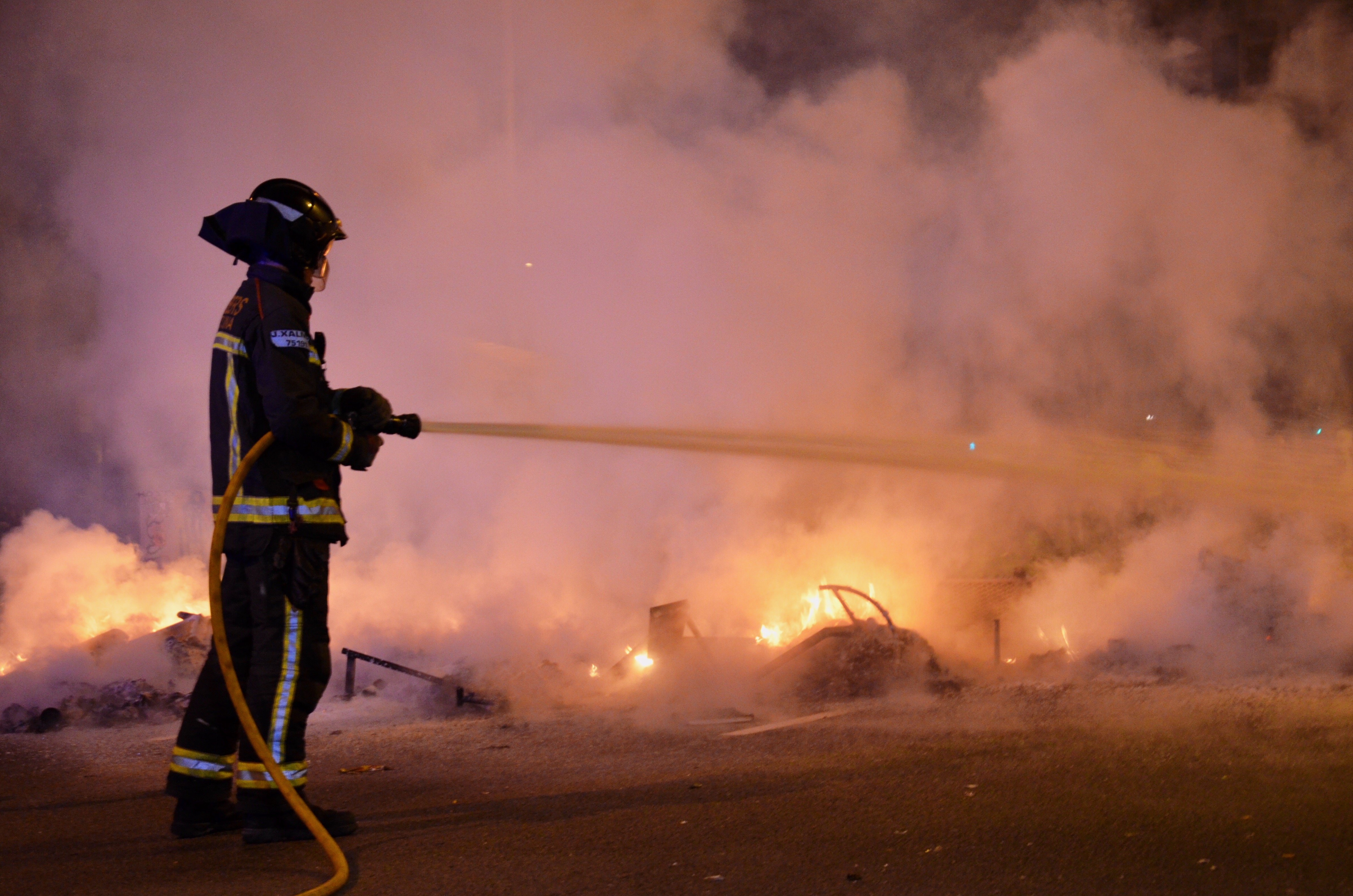Bombero apagando las barricadas creadas durante los altercados / DOBLECHECK