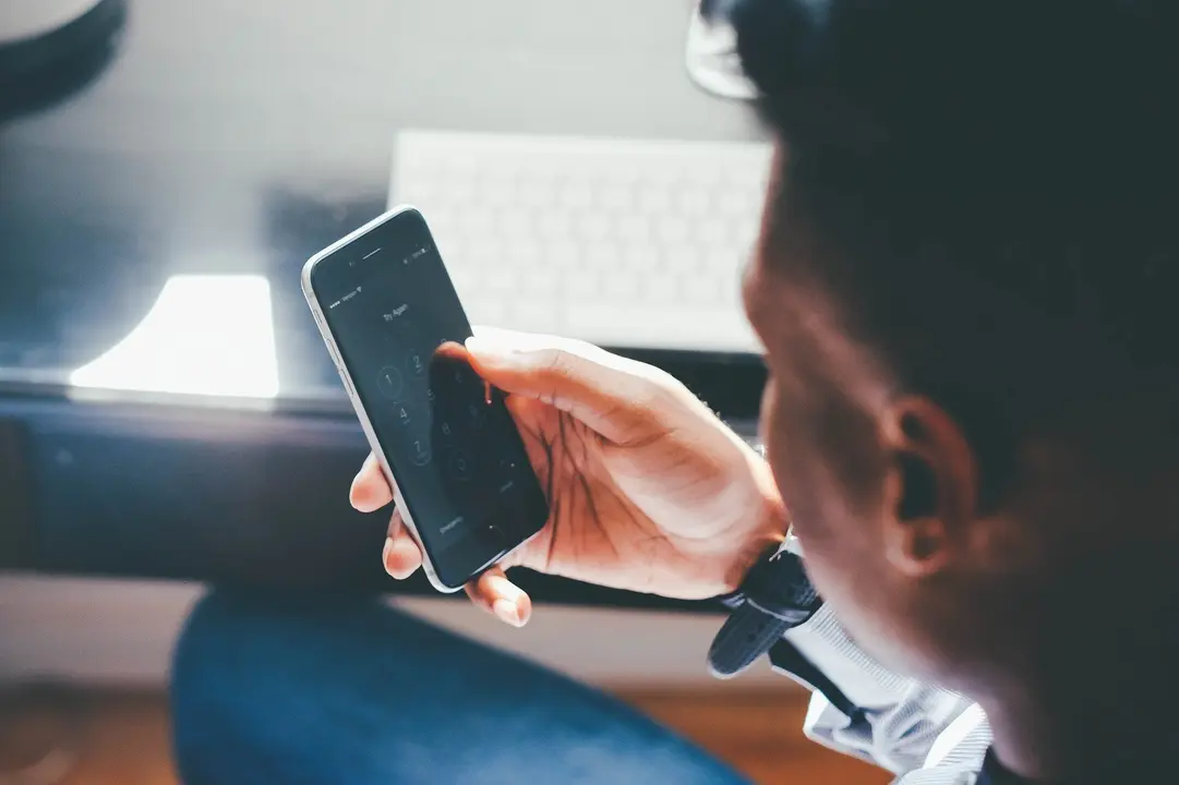 Un chico consulta su smartphone desde su casa